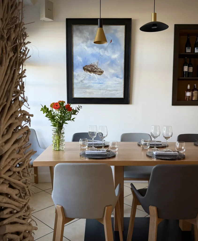 Toile de Remy de Polignac accrochée au-dessus d'une table de la salle du restaurant